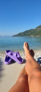 Feet on beach with purple sandals